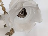 a glass vase with a white flower on it