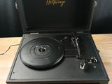 a black record player sitting on top of a wooden table