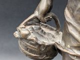 bronze statue of a woman holding a basket of flowers