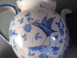 a blue and white tea pot with a bird on it