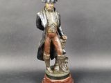 bronze statue of a man with a dog on a wooden base