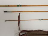 three fishing rods and a bag hanging on the wall