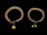 une paire de bracelets en or avec des clochettes
