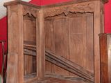 a large wooden bed with a red wall in the background
