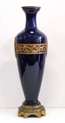 a blue vase with a gold decoration on it