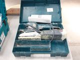 a green tool box with tools in it on the floor