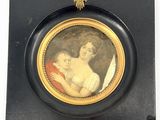 tableau représentant une femme tenant un enfant dans ses bras, dans un cadre noir