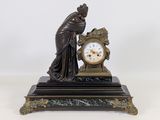 une statue de femme tenant une horloge sur une table
