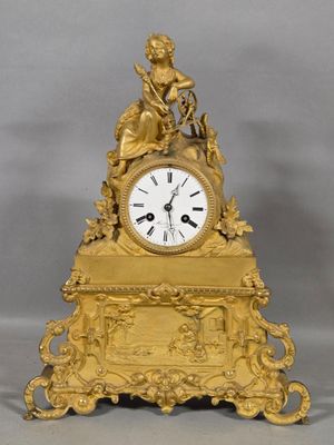 a gold clock with a statue on top of it