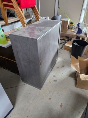 une armoire métallique au milieu d'une pièce, avec des cartons posés par terre