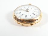 a gold pocket watch with roman numerals on the face