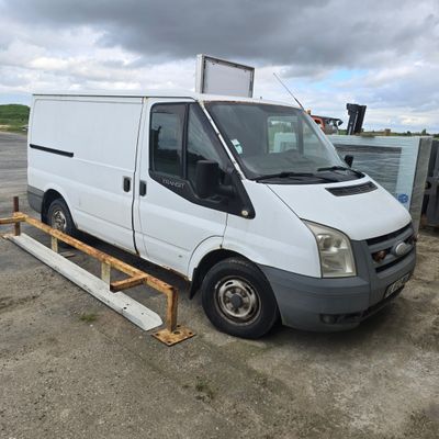 la camionnette blanche est garée dans le parking à côté d'autres véhicules