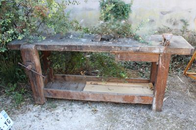 une table en bois surmontée d'une étagère, dans une cour