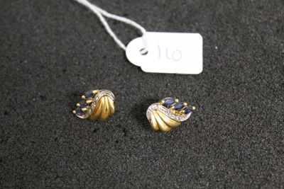 two pairs of earrings are on a black surface next to a price tag