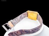 a white plate with a piece of cheese and a watch on it