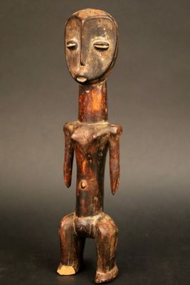 une statue en bois représentant un homme avec un visage et des jambes