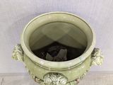 a large green vase with a black cat inside of it