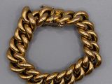 gros plan d'un bracelet en or sur une surface grise