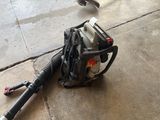 a small blower sitting on the ground next to a skateboard
