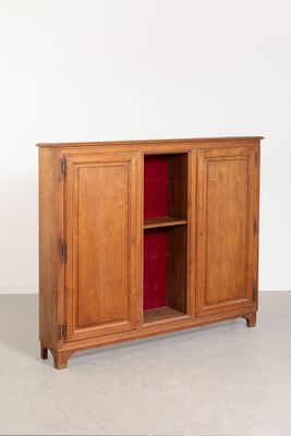 une armoire en bois avec une porte rouge dans une pièce