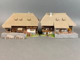 deux petites maisons, chacune dotée d'un toit de chaume