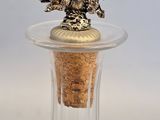 a glass bottle with a dog on top and a cork stopper