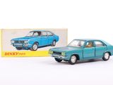 une image représentant une petite voiture bleue posée à côté d'une boîte de « Dinky Toys »