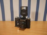 a camera sitting on a table with a flash light on it