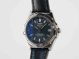a close up of a watch with a blue dial on a black strap