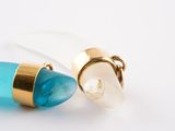 two pieces of jewelry that are sitting on a white surface