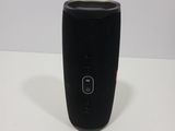 a close up of a black speaker sitting on top of a table