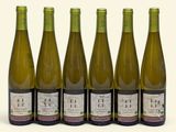 six bouteilles de vin sont alignées sur une surface blanche