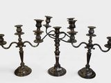three candlesticks are standing in a row on a white surface