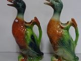 two ceramic ducks that are standing next to each other