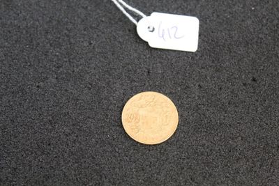 a gold coin on the ground next to a price tag