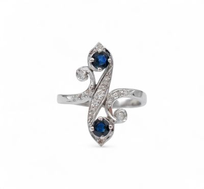 a close up of a diamond and sapphire ring on a white background