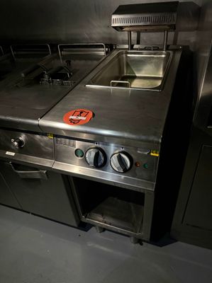 une grande cuisine en inox équipée d'un évier et d'une cuisinière