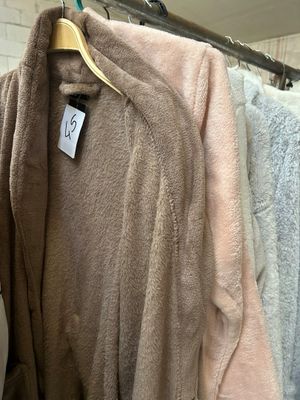 many coats hanging on a rack in a store