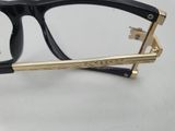 the glasses are black and gold and have a gold bar on the temples