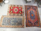 Trois tapis sont disposés sur le sol dans une pièce.
