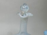 a glass vase with a bird on top of it