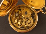 a close up of a gold pocket watch on a table