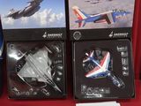 trois boîtes contenant un assortiment de maquettes d'avions, posées sur une surface rouge