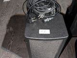une enceinte noire posée sur une table en bois