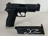 a black gun with a signature on it and a magazine holder