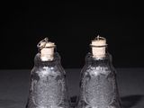 pair of clear glass salt and pepper shakers with cork stoppers