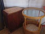 une petite table avec un plateau en verre, sur laquelle se trouve un panier en osier