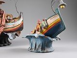 two figurines of a man and a woman on a boat