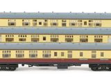 four toy trains are lined up in a row on a white surface