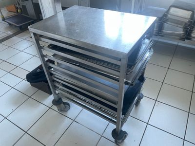 un chariot métallique sur lequel sont posées plusieurs casseroles, dans une cuisine